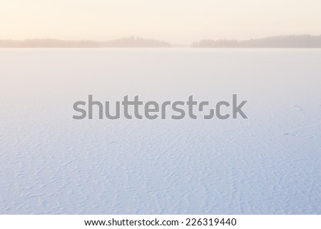Serene winter morning view to frozen lake