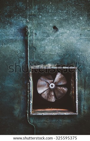Air conditioning duct and rusted fan on abandoned factory grunge ceiling