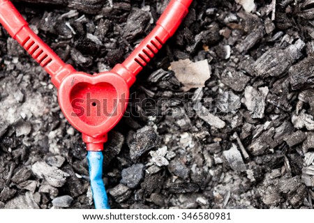 Abandoned plastic toy stethoscope on burned ground