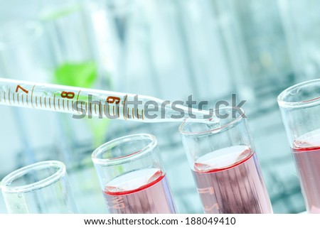 Research in chemistry lab, dropping liquid or solution into test tube.