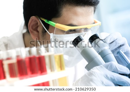 Chemist is analyzing sample in laboratory room.