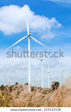green meadow with wind turbines generating electricity