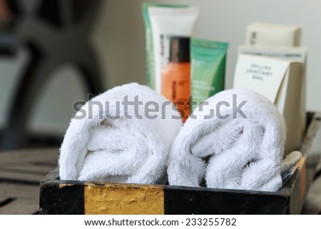 Hotel cosmetics kit and towel in basket