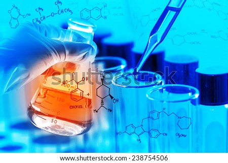 Gloved hand holding a flask, with chemical equations background, in laboratory