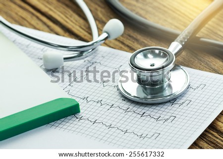 part of stethoscope with cardiogram and medical check-up report for healthcare concept