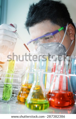 A researcher is analyzing sample in laboratory room.