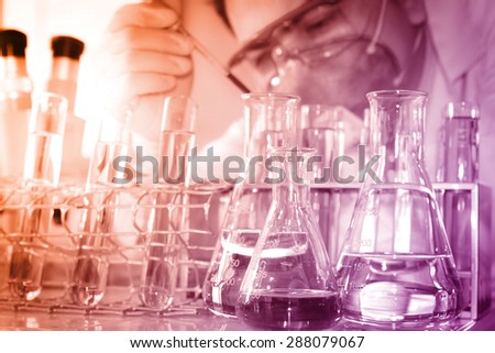 A researcher is analyzing sample in laboratory room.