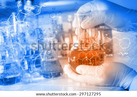 A researcher working in laboratory with periodic table and chemical equations background