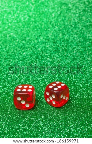 Red dices over a green glittering background