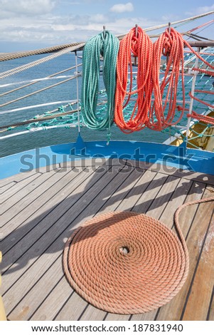 Thick rope in spiral or ring shape on a wooden sailing ship floor