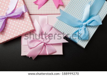 Gift packages tied with ribbons on black background