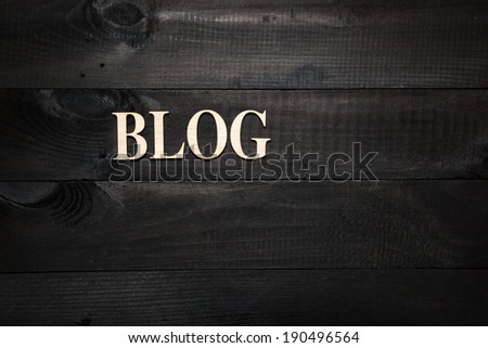 Wooden letters forming word BLOG written on black wooden background