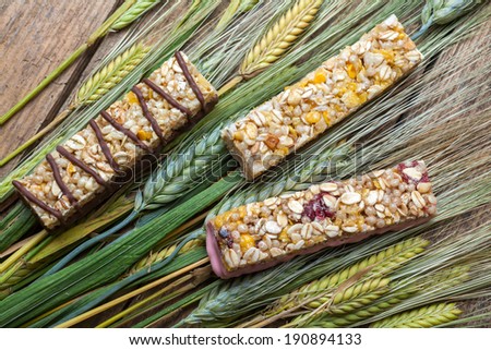 Cereal bars and dry wheat on a wooden table