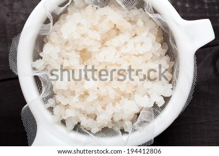 Water kefir grains into a plastic strainer
