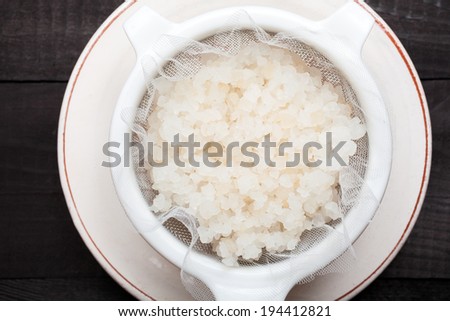 Water kefir grains into a plastic strainer