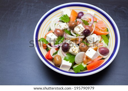 Greek vegetable salad with tomato, onion, cucumber, parsley, olives and feta cheese