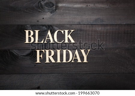 Wooden letters forming words BLACK FRIDAY written on black wooden background