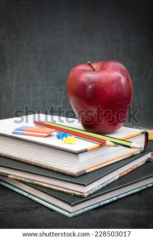 Apple on books and chalkboard for background
