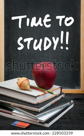 Apple on books and time to study handwritten on the chalkboard in the background