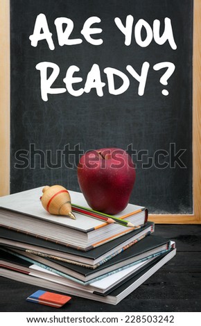 Apple on books and Are you ready? handwritten on the chalkboard in the background