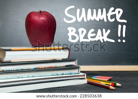Apple on books and summer break!! handwritten on the chalkboard in the background