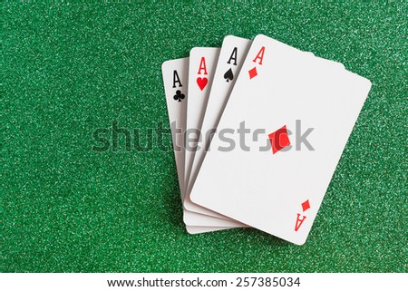 A winning poker hand of four aces playing cards suits on green