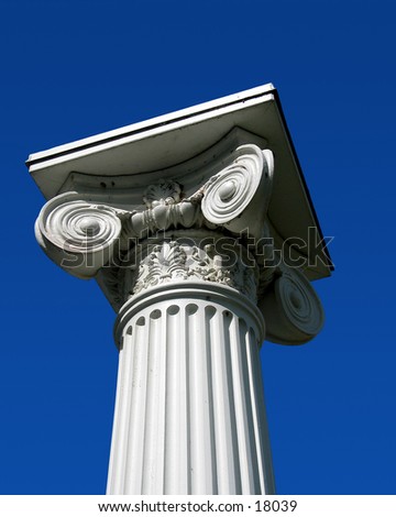 Top of white pillar against sky.