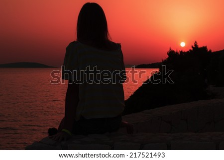 Woman watching the sunset over the Adriatic Sea
