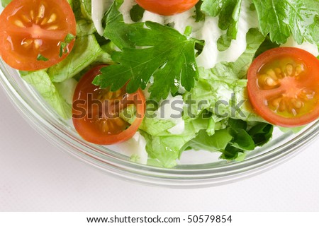 Vegetables salad in a glass salad bowl over white background