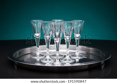 shot glasses on a silver tray with a blueish background