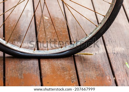 Rusted wheel bicycle flat tire on wood floor