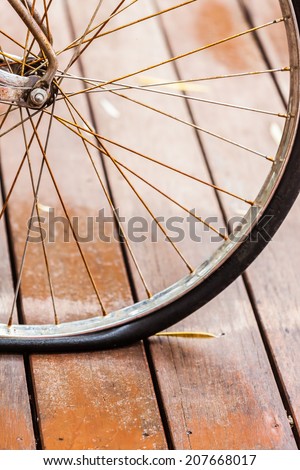 Rusted wheel bicycle flat tire on wood floor
