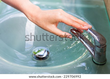 girl washing her hand and turn off faucet out door