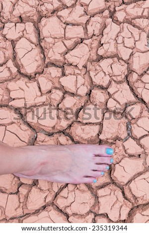 Nake woman foot walk on walk on cracked earth background