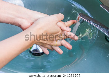 girl washing her hand out door