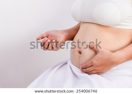 Pregnant woman with syringe,pregnancy health