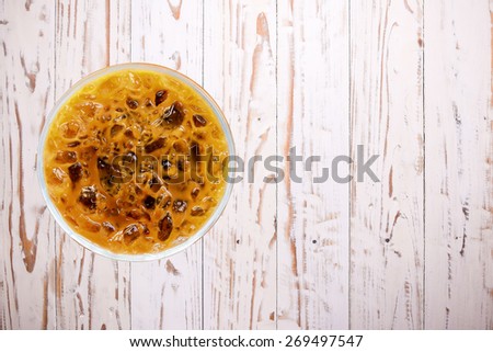 Iced coffee in plastic cup on wood white table  (top view)