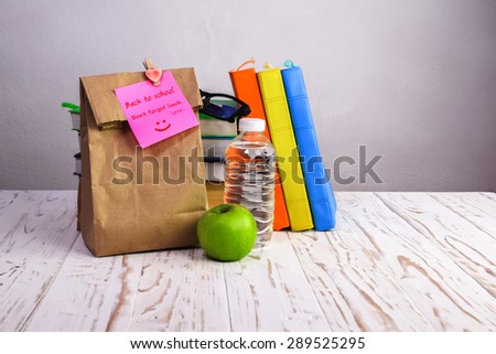 Back to School Lunch ,Don\'t forget lunch , paper lunch bag with apple,water and books on desk with post-it note,