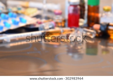 Blurred of Glass Medicine Vials medicine pill and capsule Syringe on x-ray film over doctor table for background (shallow DOF)