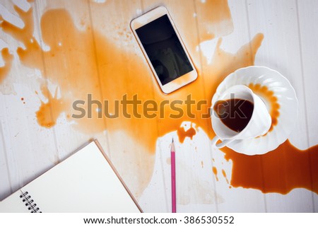 On office desk ,Coffee spilled on mobile phone (concept for working hard, clumsy or repair service)