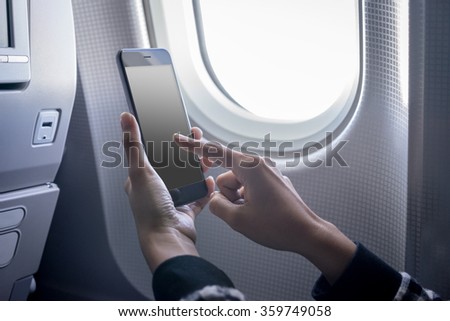 holding digital mobile phone at airplane