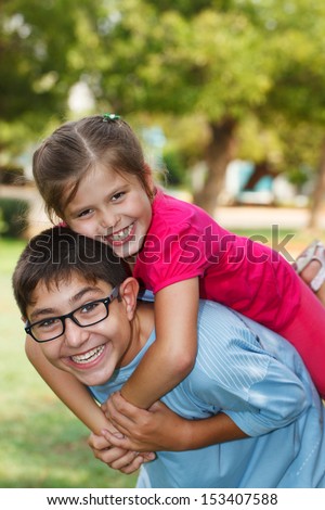 Children playing piggy back, looking at the camera.