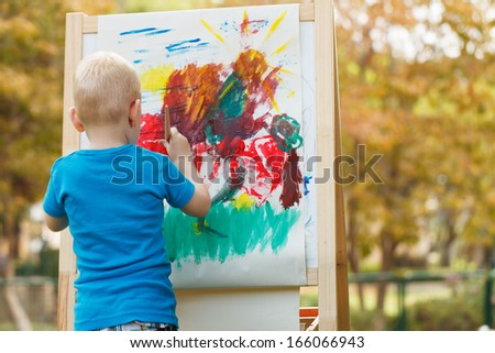 Preschooler girl Painting at the nature