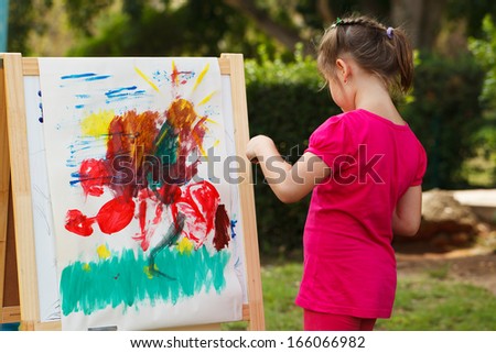 Preschooler girl Painting at the nature