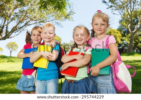 Preschoolers with books outside