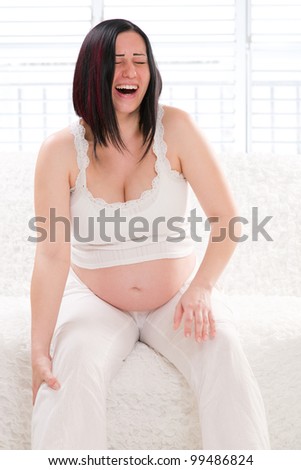 Pregnant Woman at home with a pain in the leg.