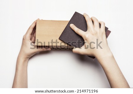 hands hold the sanding paper with wood block isolated white.