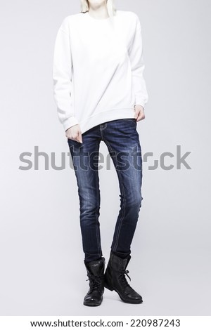 Front view of a standing woman(female) model wearing blue denim(trousers) with boots and white top isolated on a white background