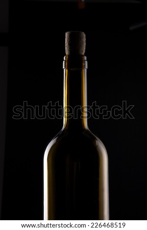 A yellow wine bottle with cork isolated black.