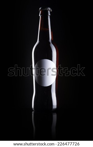 A beer glass bottle with liquor with blank circle label reflective bottom isolated black.